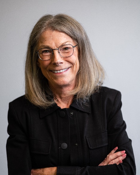 A person with glasses smiling
Description automatically generated