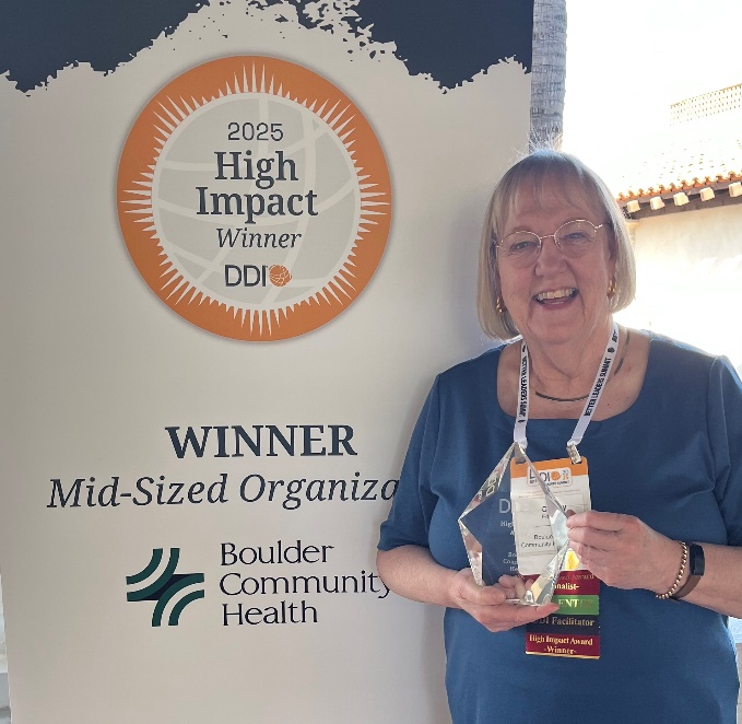 A person standing in front of a sign

Description automatically generated