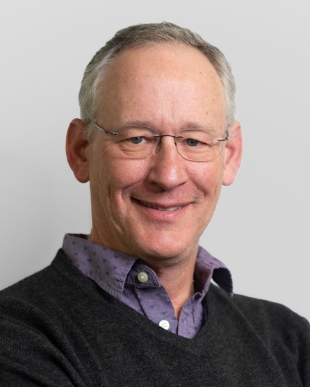 A person wearing glasses and a black sweater
Description automatically generated