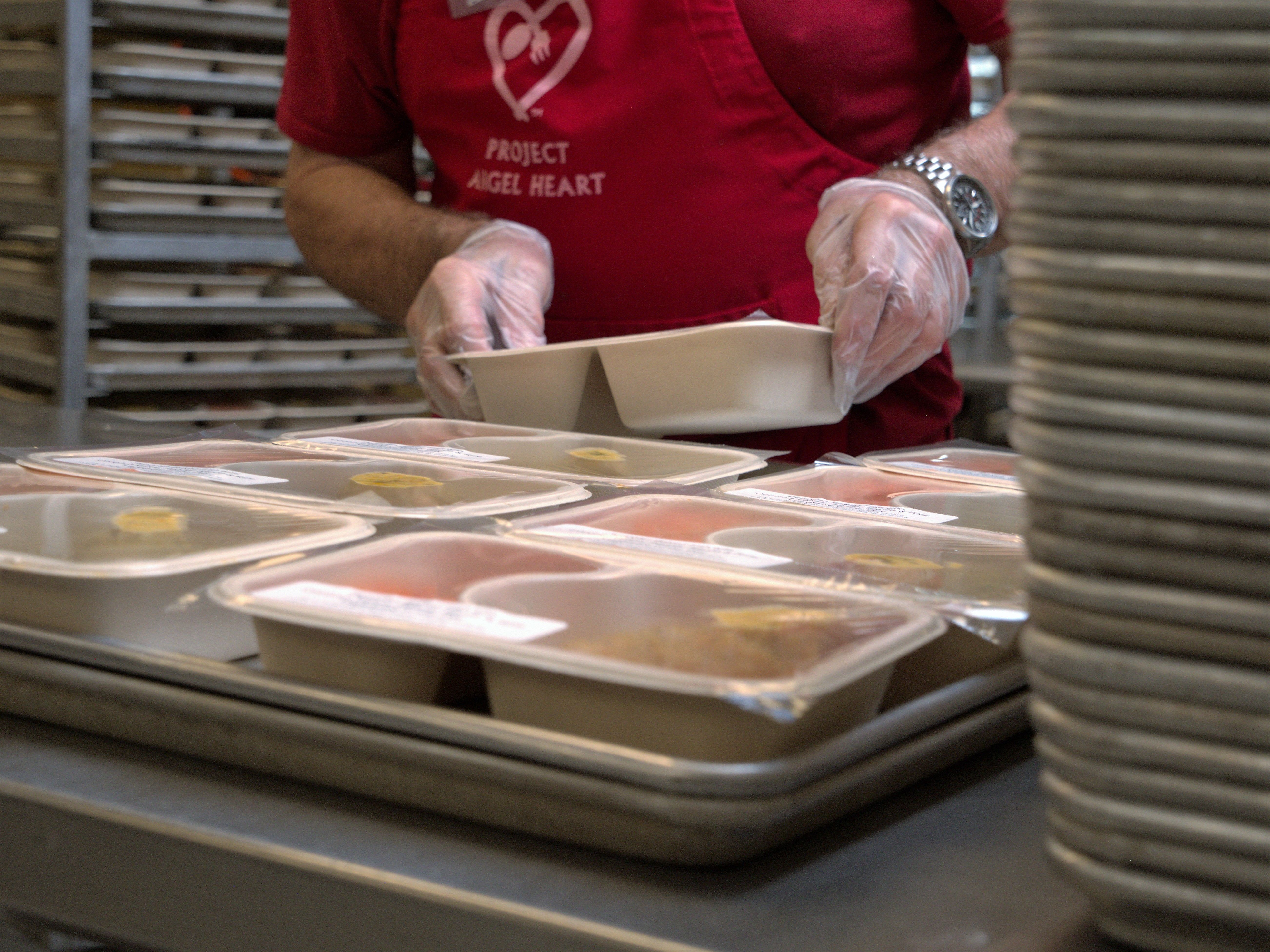 Project Angel Heart volunteer packs a healthy meal for delivery to a patient