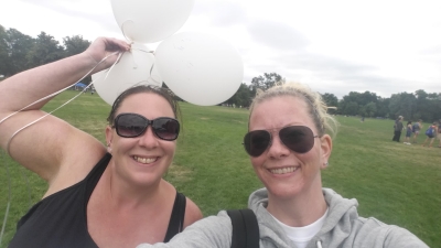 two woman smiling holding balloons