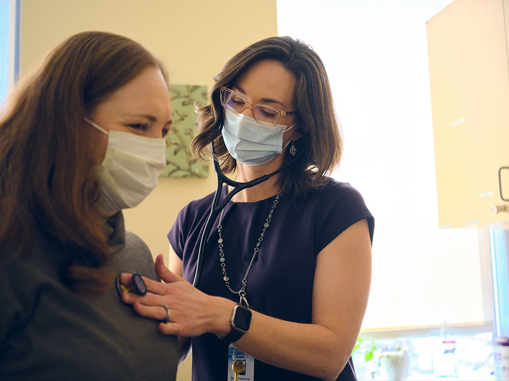doctor wearing mask checking patient heart with stethoscope 